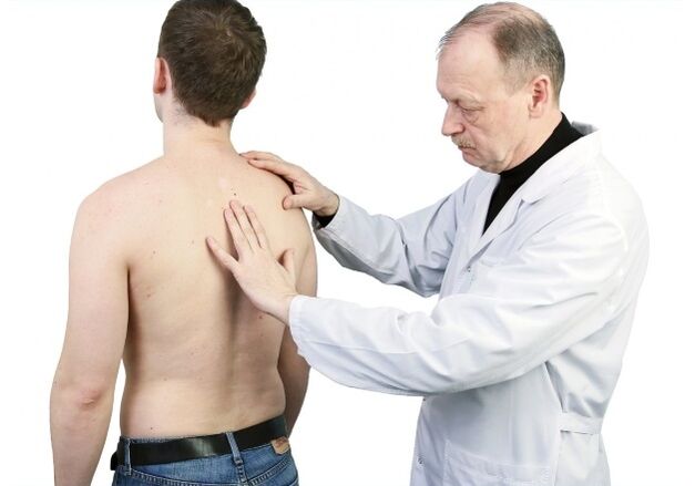 the doctor examines the back with osteochondrosis